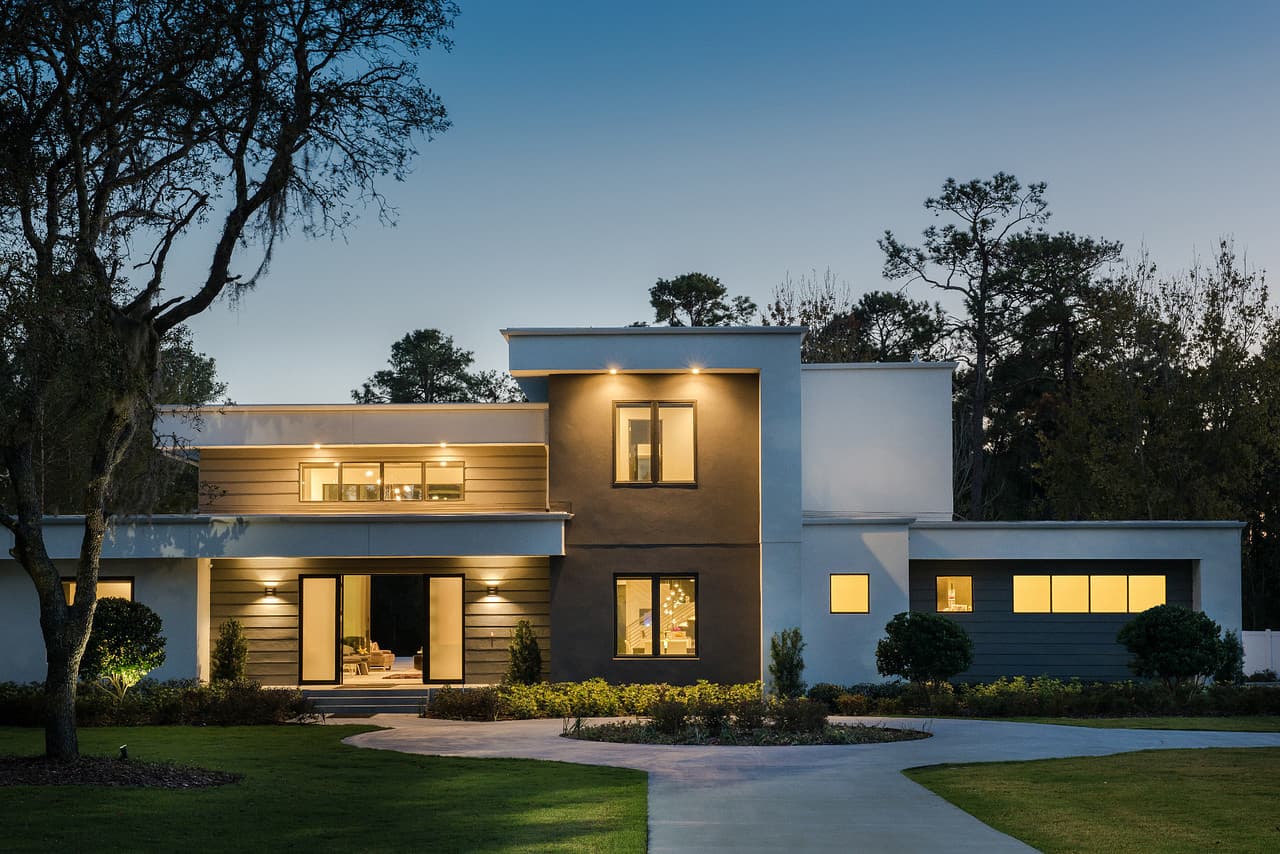 A contemporary luxury home at dusk, lit by integrated Control4 lighting