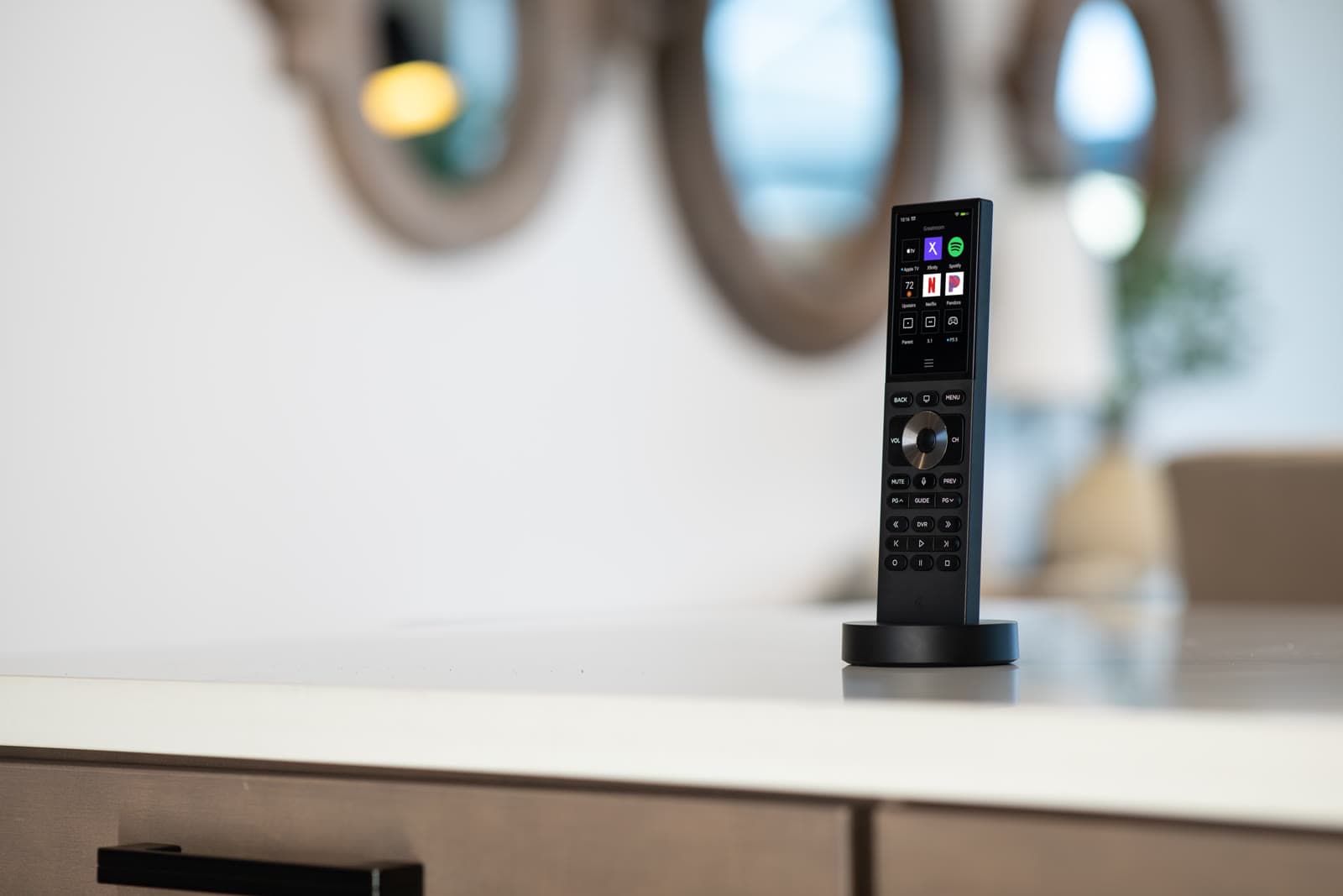 A Control4 handheld remote in its dock in a luxury home