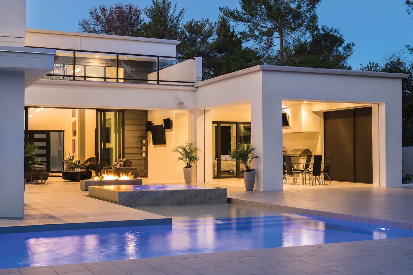 A poolside terrace lit for an evening, seen from an angle