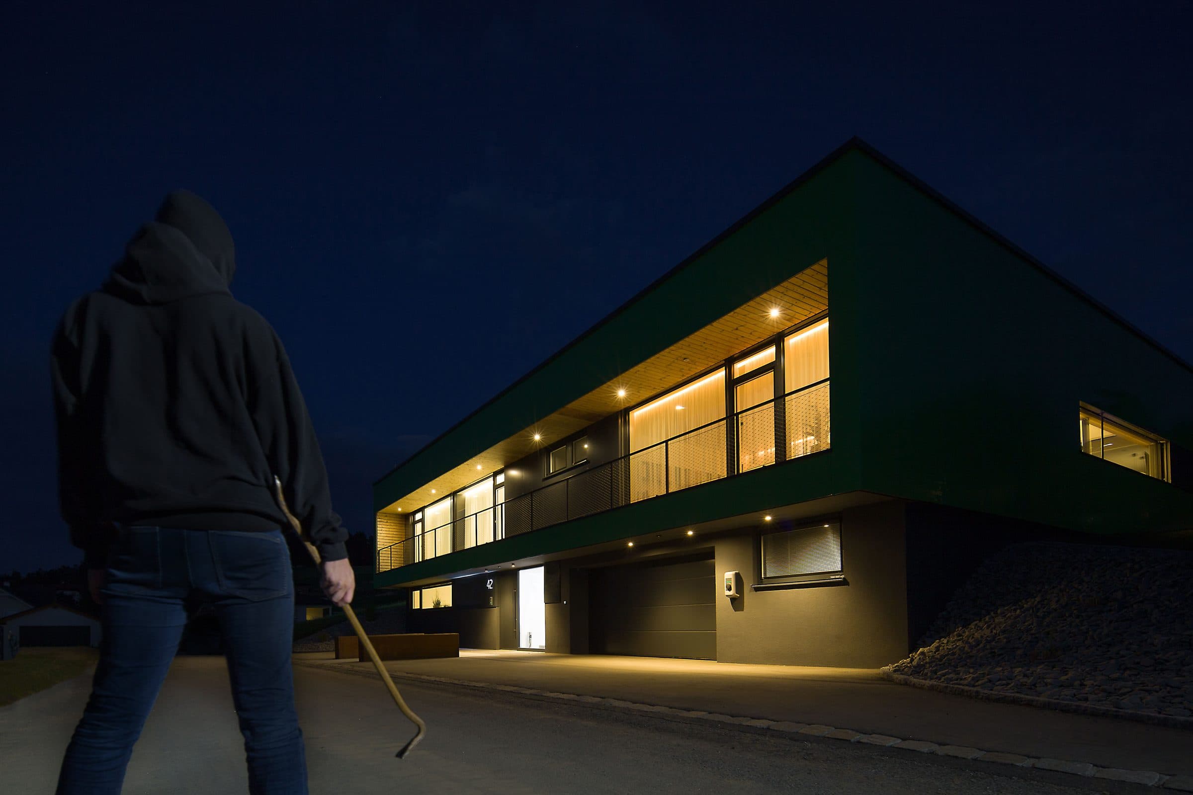 A modern home lit and watched over at night
