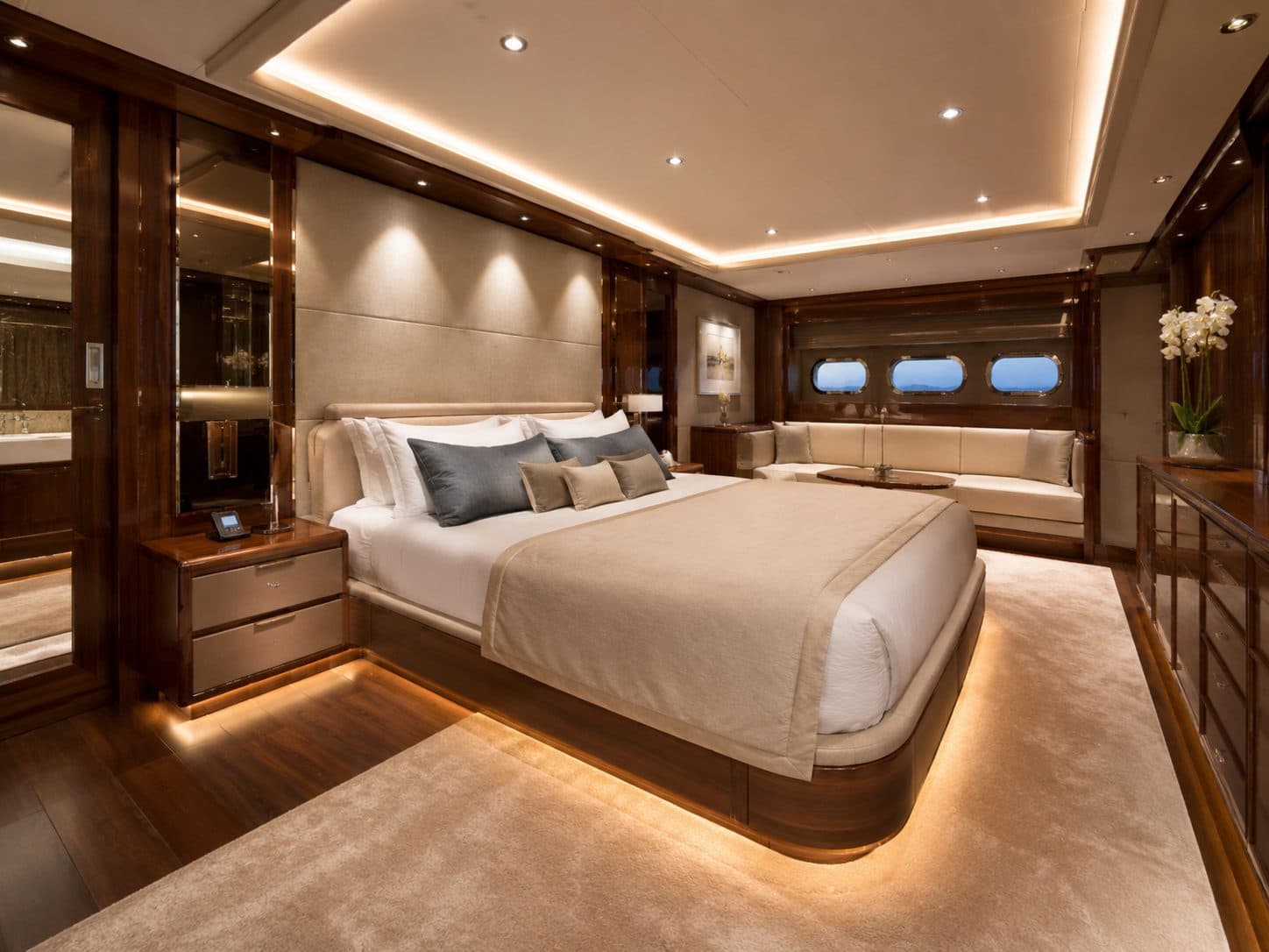 A yacht master cabin with warm, layered cove lighting
